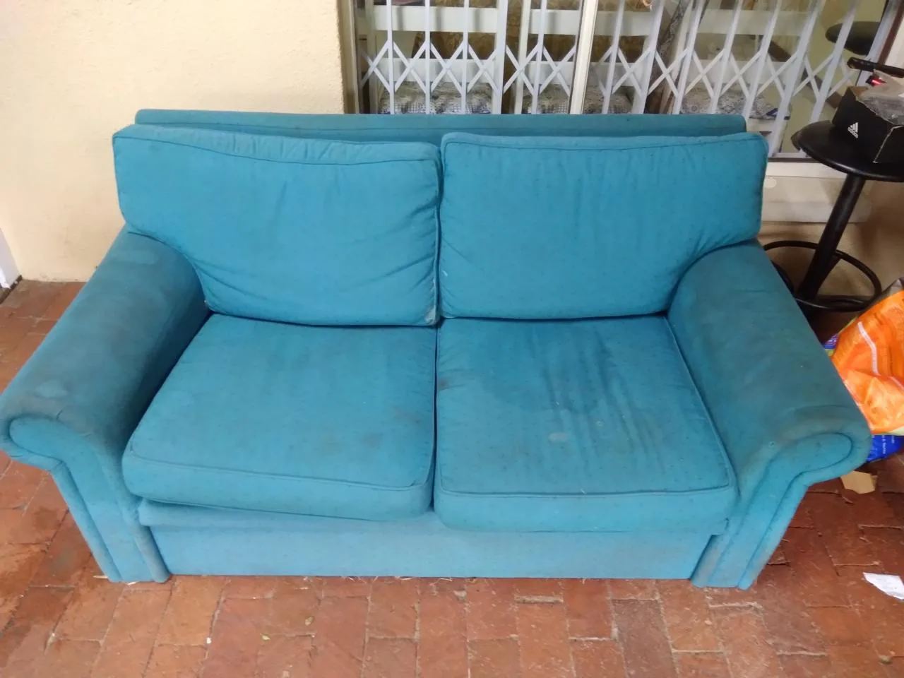 Blue upholstered couch before cleaning
